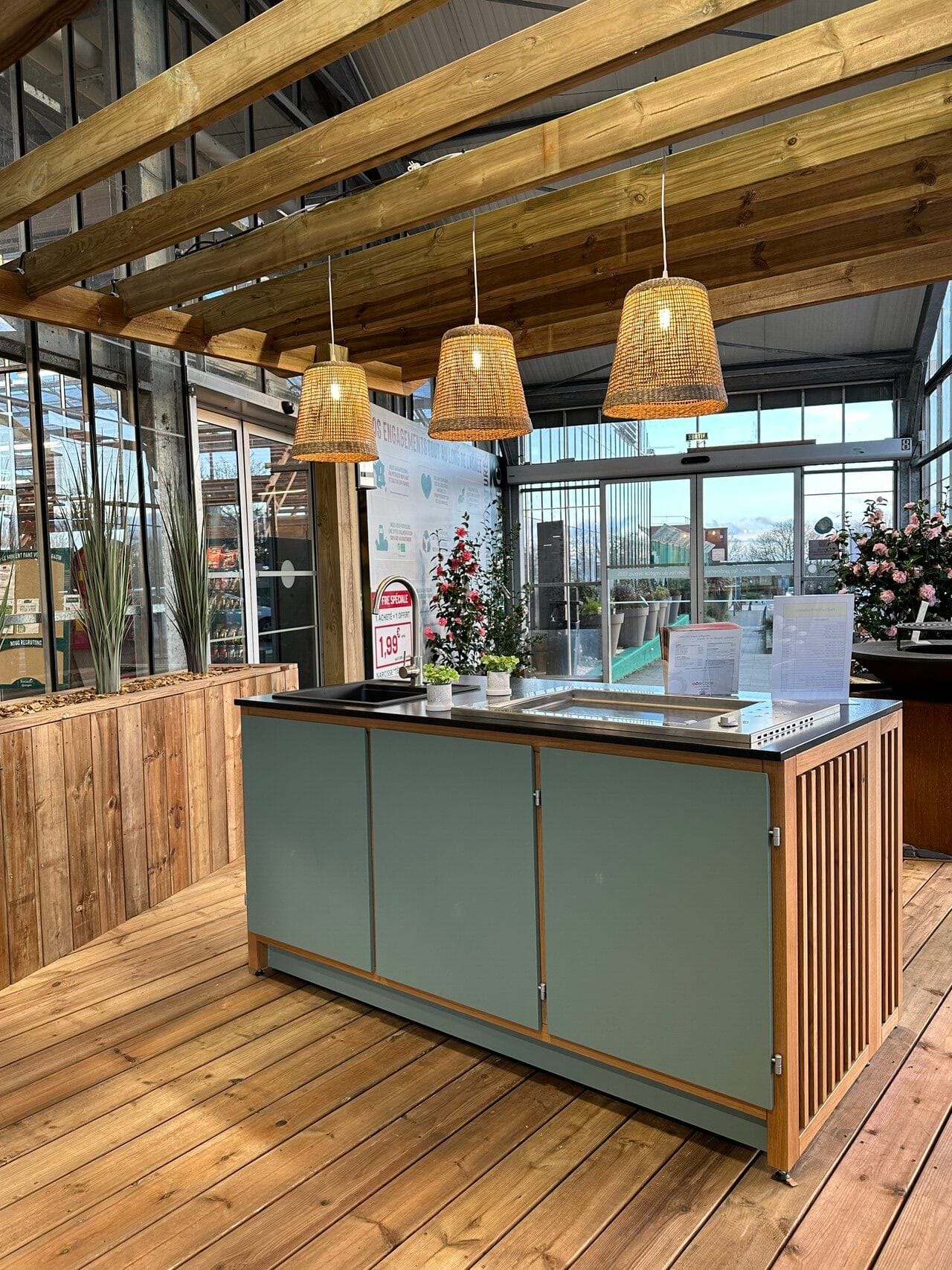 Îlot de cuisine extérieur sous pergola avec luminaires tressés.