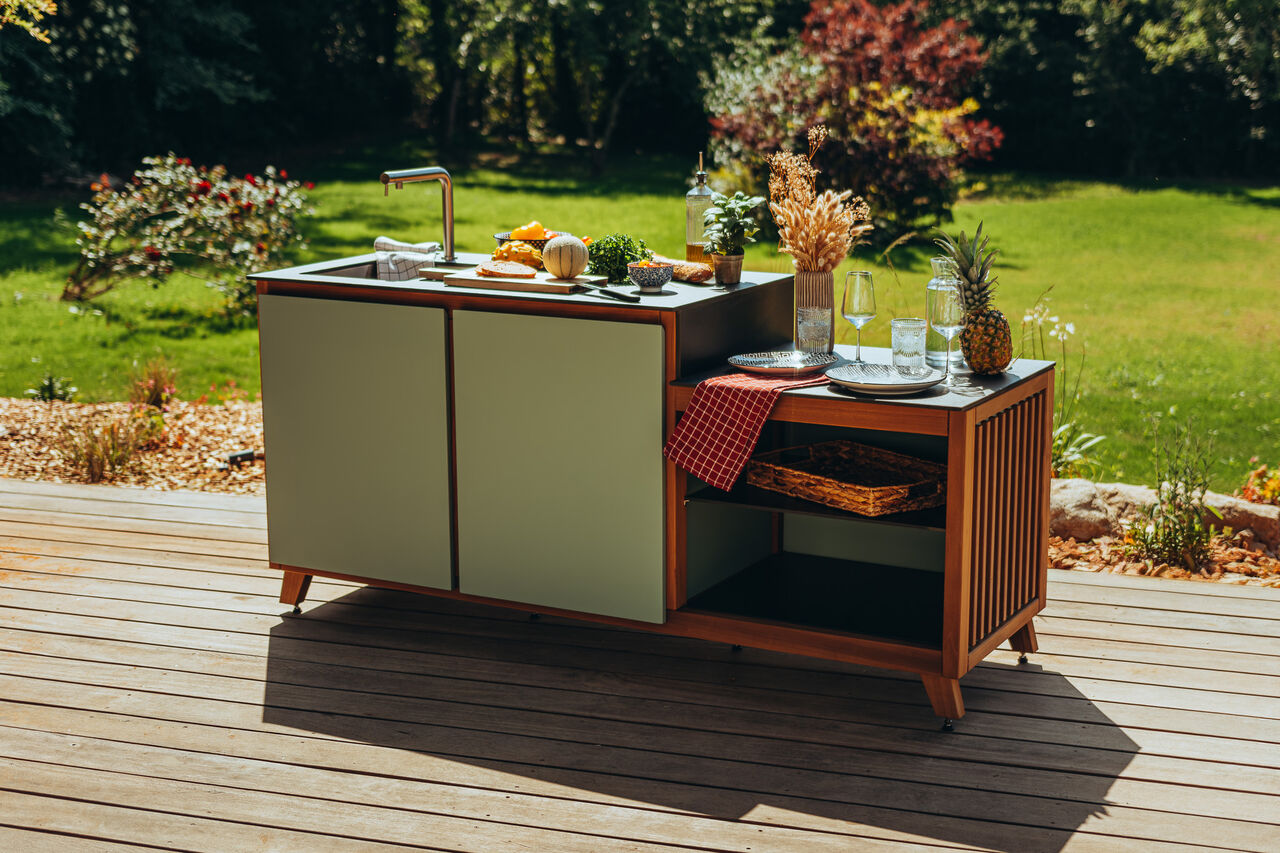 Cuisine d'extérieur moderne sur une terrasse en bois.