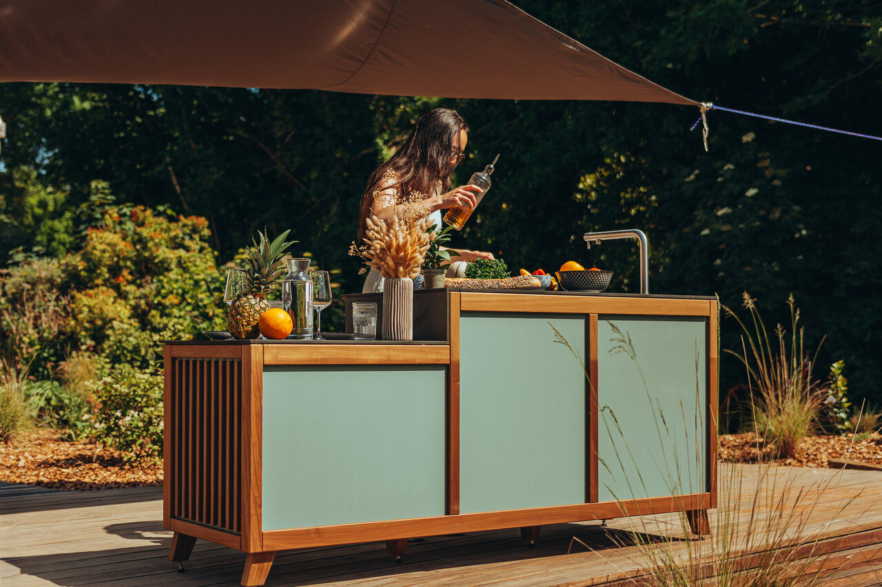 Femme cuisinant sur une station de cuisine d'été extérieure.