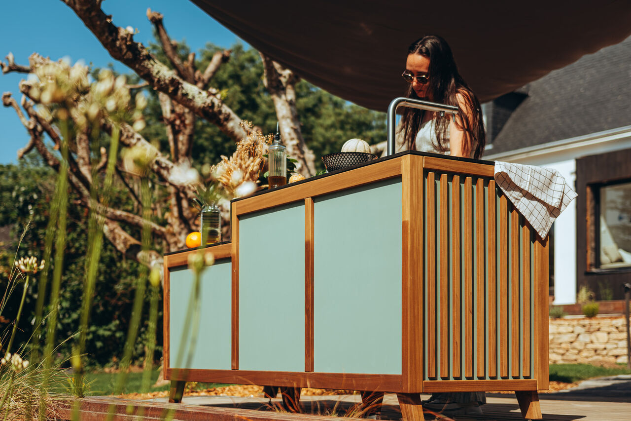 Cuisine d'été moderne en bois et vert dans un jardin.