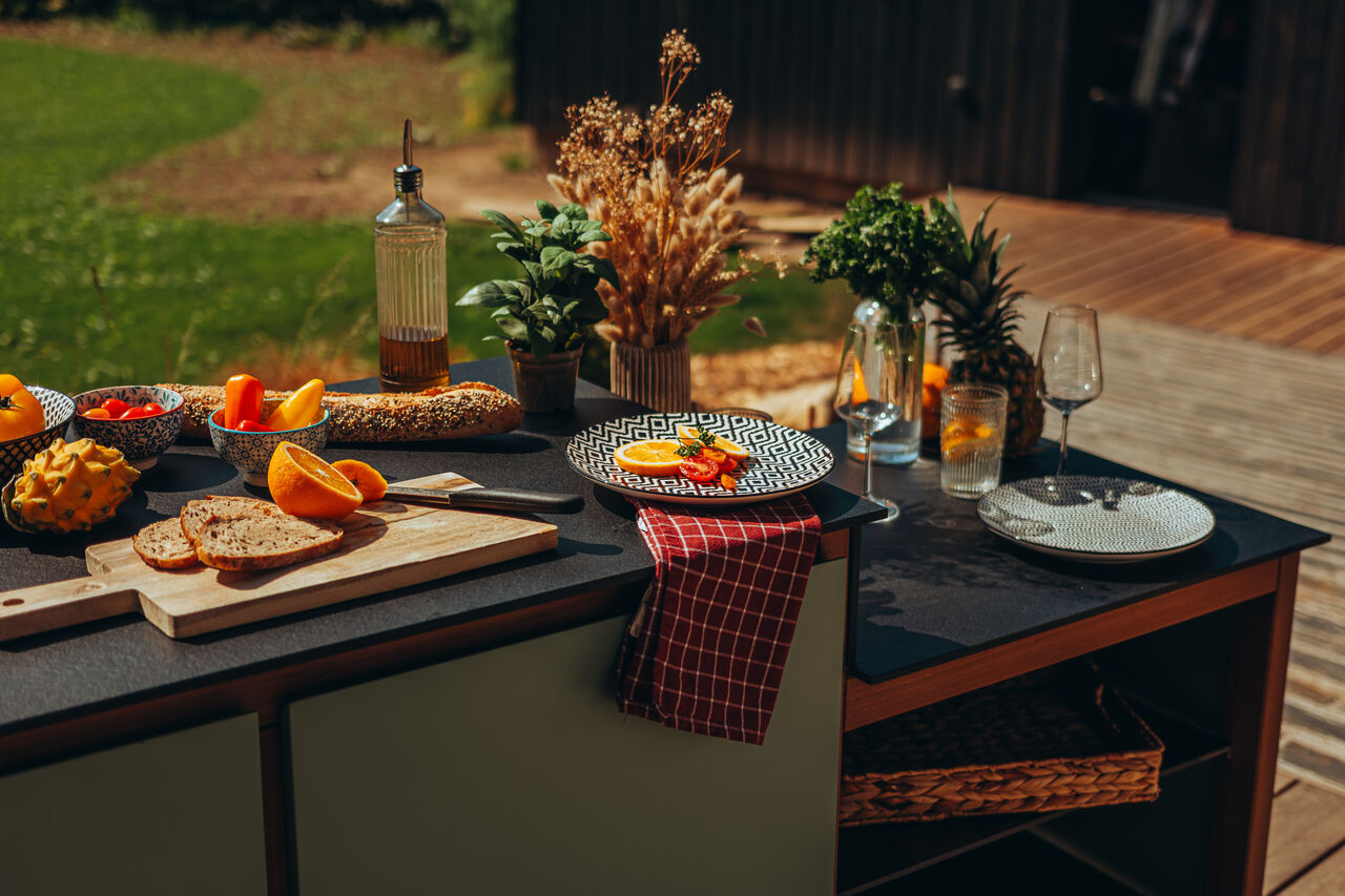 Cuisine extérieure avec pain, fruits et décorations de table.
