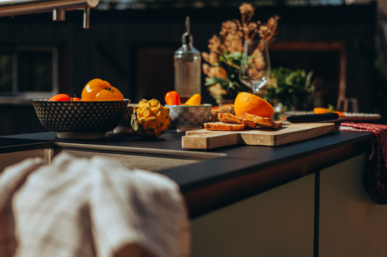 Fruits et légumes sur un comptoir de cuisine ensoleillé.